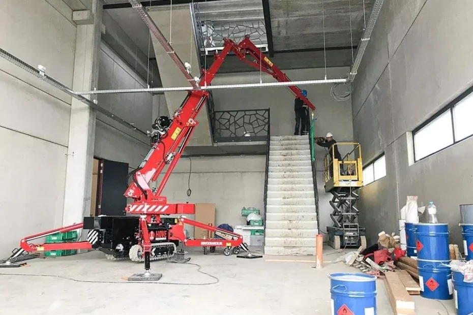 Mini grue PRO2MAT dans un bâtiment en construction pour le levage de matériel précis dans un chantier en intérieur restreint.