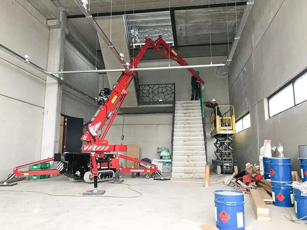 Mini grue PRO2MAT dans un bâtiment en construction pour le levage de matériel précis dans un chantier en intérieur restreint.