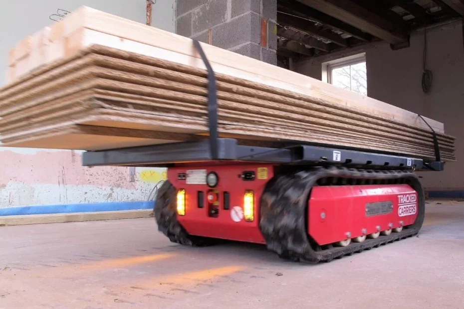 Transporteur à chenilles P'tit Mulet PRO2MAT déplaçant des planches, illustrant l'efficacité du matériel de levage.